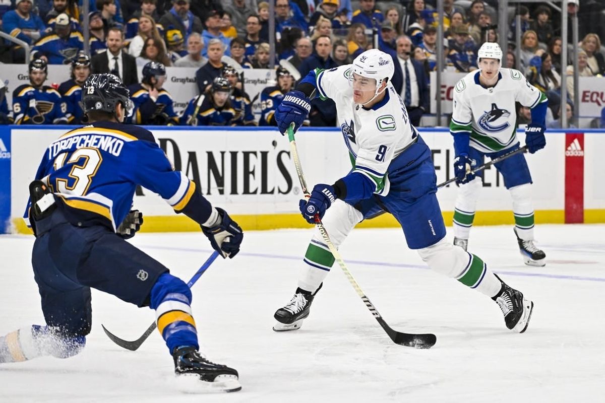 Jan 4, 2024; St. Louis, Missouri, USA;  Vancouver Canucks defenseman Nikita Zadorov (91) shoots as St. Louis Blues right wing Alexey Toropchenko (13) defends during the first period at Enterprise Center.