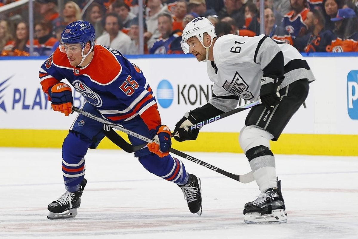 Apr 24, 2024; Edmonton, Alberta, CAN; Edmonton Oilers forward Dylan Holloway (55) and Los Angeles Kings forward Trevor Lewis (61) looks for a loose puck during the first period in game two of the first round of the 2024 Stanley Cup Playoffs at Rogers Place.