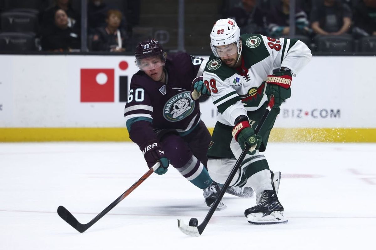 Mar 19, 2024; Anaheim, California, USA; Minnesota Wild center Frederick Gaudreau (89) skates with the puck against Anaheim Ducks defenseman Jackson LaCombe (60) during the third period of a game at Honda Center.