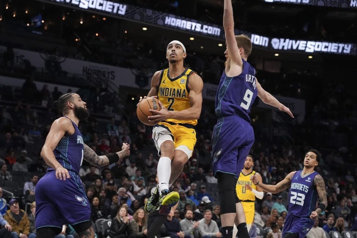 Feb 12, 2024; Charlotte, North Carolina, USA; Indiana Pacers guard Andrew Nembhard (2) goes up for a layup defended but Charlotte Hornets forward Davis Bertans (9) during the second quarter at Spectrum Center.