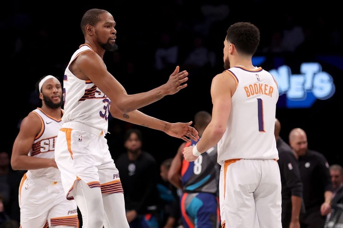 Jan 31, 2024; Brooklyn, New York, USA; Phoenix Suns forward Kevin Durant (35) high fives guard Devin Booker (1) during the third quarter against the Brooklyn Nets at Barclays Center.
