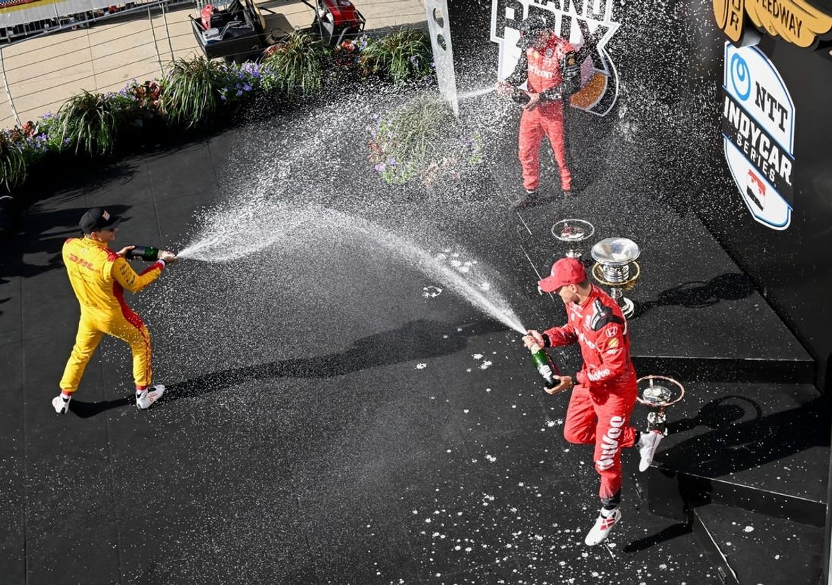Chip Ganassi Racing driver Alex Palou (10), Team Penske driver Will Power (12) and Rahal Letterman Lanigan Racing driver Christian Lundgaard (45) spray each other with champaign Saturday, May 11, 2024, during the Sonsio Grand Prix at Indianapolis Motor Speedway.
