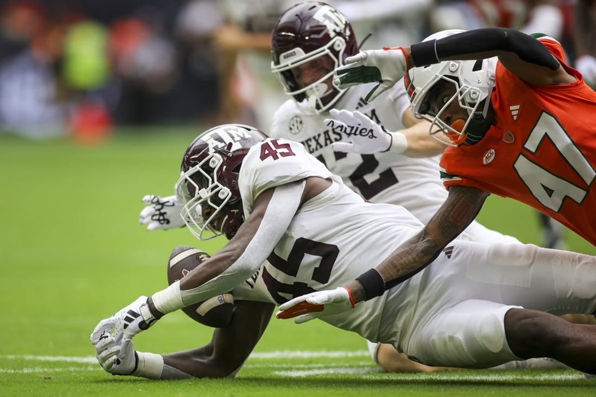 Aggies linebacker Edgerrin Cooper (45) recovers a fumble against the Miami Hurricanes during the second quarter at Hard Rock Stadium.