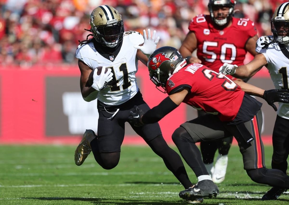 Dec 31, 2023; Tampa, Florida, USA;New Orleans Saints running back Alvin Kamara (41)  stiff arms Tampa Bay Buccaneers safety Antoine Winfield Jr. (31) during the first quarter at Raymond James Stadium.