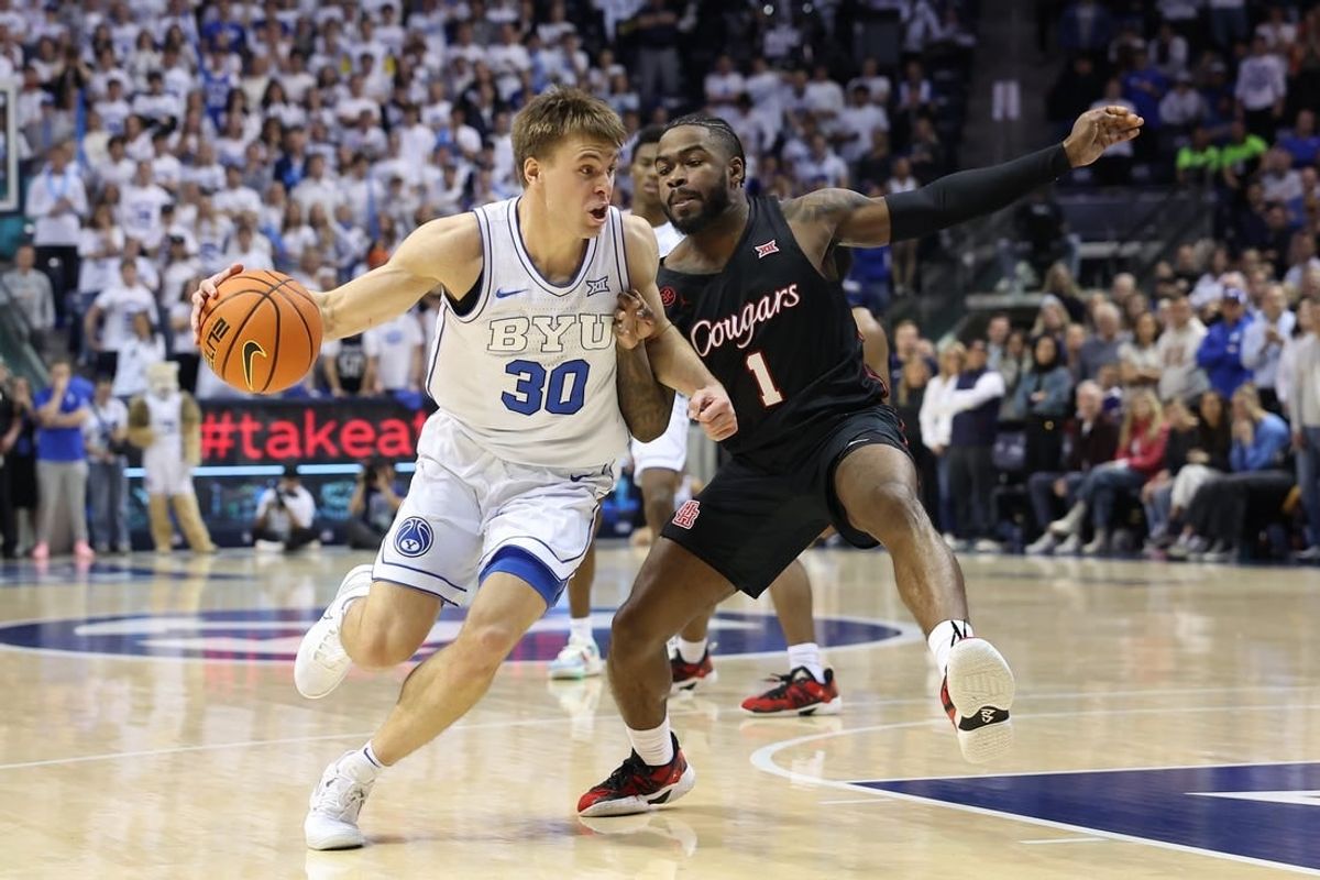 Jan 23, 2024; Provo, Utah, USA; Brigham Young Cougars guard Dallin Hall (30) drives the ball against Houston Cougars guard Jamal Shead (1) during the second half at Marriott Center.