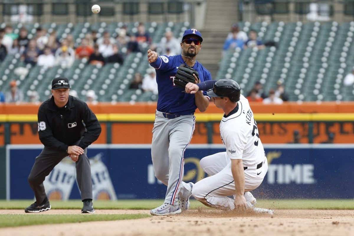 Apr 17, 2024; Detroit, Michigan, USA; Texas Rangers second baseman Marcus Semien (2) throws to first after tagging out Detroit Tigers second baseman Colt Keith (33) at second base during the second inning of the game at Comerica Park.