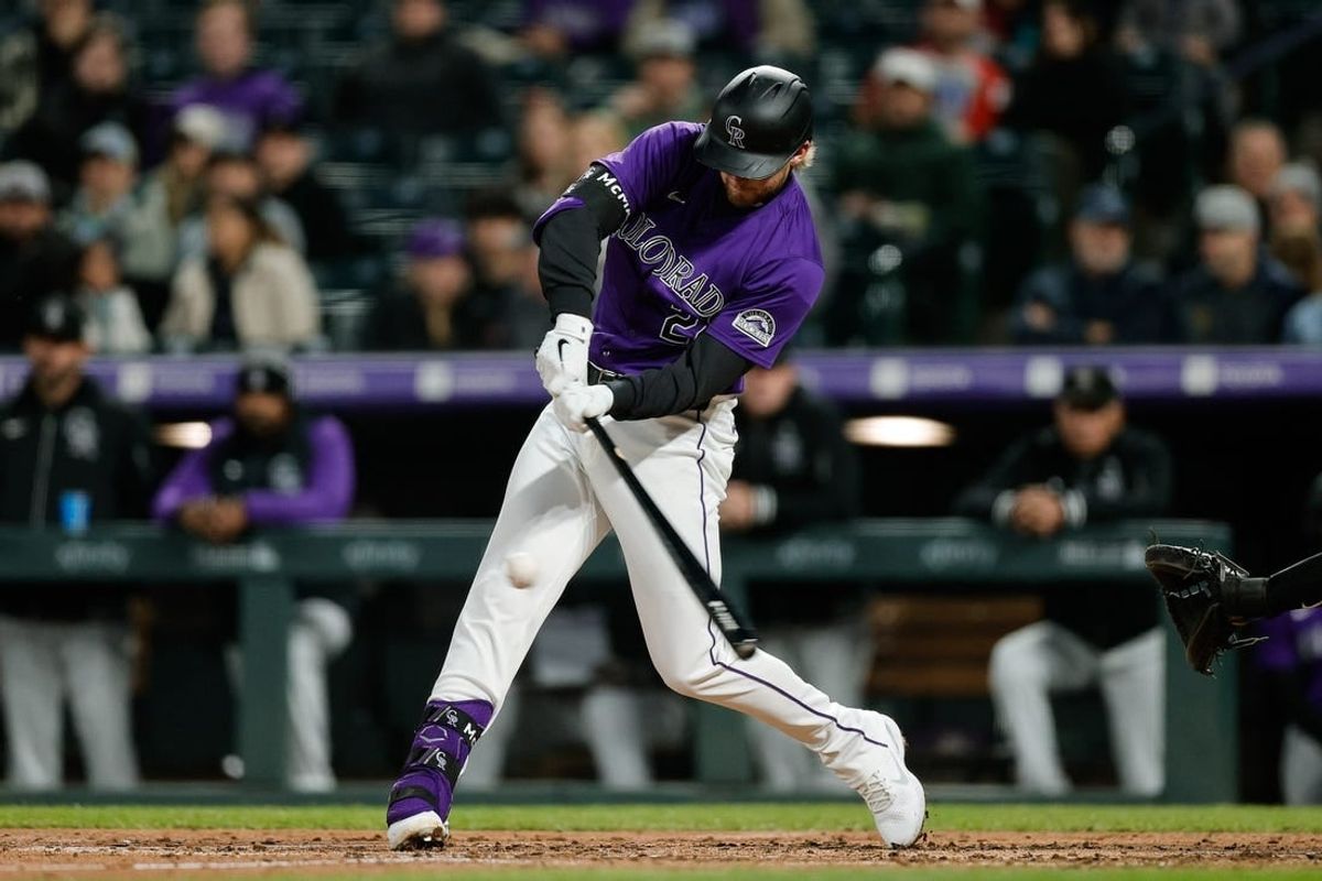 Apr 8, 2024; Denver, Colorado, USA; Colorado Rockies third base Ryan McMahon (24) hits a single in the fourth inning against the Arizona Diamondbacks at Coors Field.