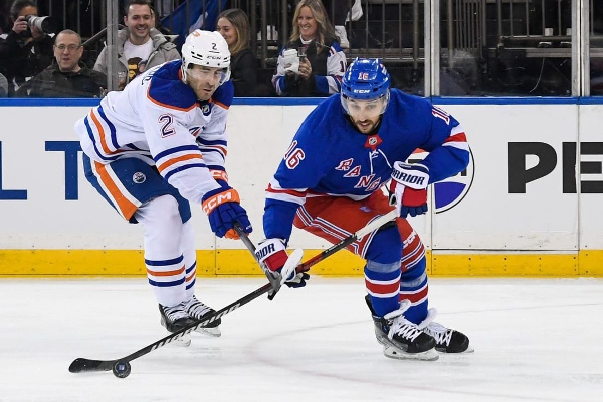 Dec 22, 2023; New York, New York, USA;  Edmonton Oilers defenseman Evan Bouchard (2) defends against New York Rangers center Vincent Trocheck (16) during the second period at Madison Square Garden.