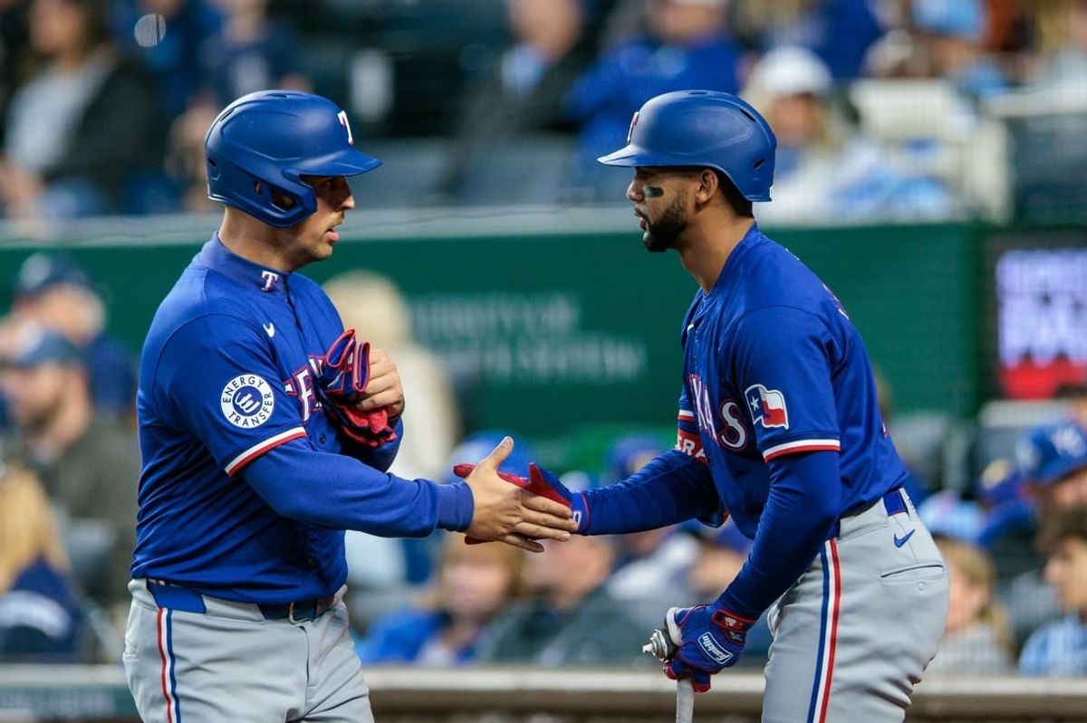 May 4, 2024; Kansas City, Missouri, USA; Texas Rangers first base Nathaniel Lowe (30) slaps hands with Texas Rangers outfielder Leody Taveras (3) after scoring during the seventh inning against the Kansas City Royals at Kauffman Stadium.