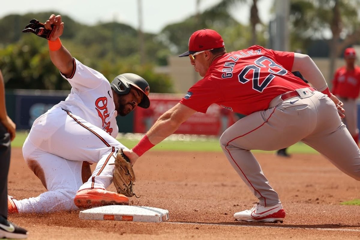 Mar 16, 2024; Sarasota, Florida, USA;  Baltimore Orioles right fielder Anthony Santander (25) slides safe into third base as Boston Red Sox third baseman Romy Gonzalez (23) attempted to tag him out first inning at Ed Smith Stadium.