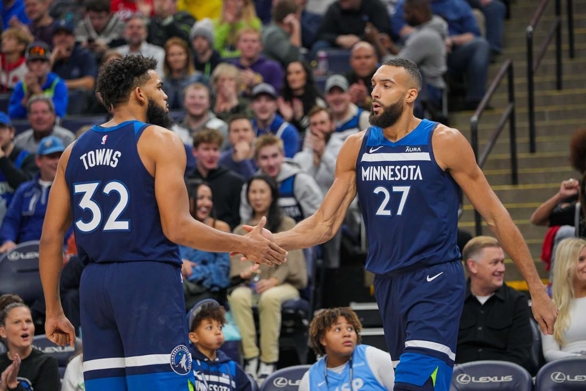 Nov 22, 2023; Minneapolis, Minnesota, USA; Minnesota Timberwolves center Karl-Anthony Towns (32) congratulates center Rudy Gobert (27) against the Philadelphia 76ers in the third quarter at Target Center.