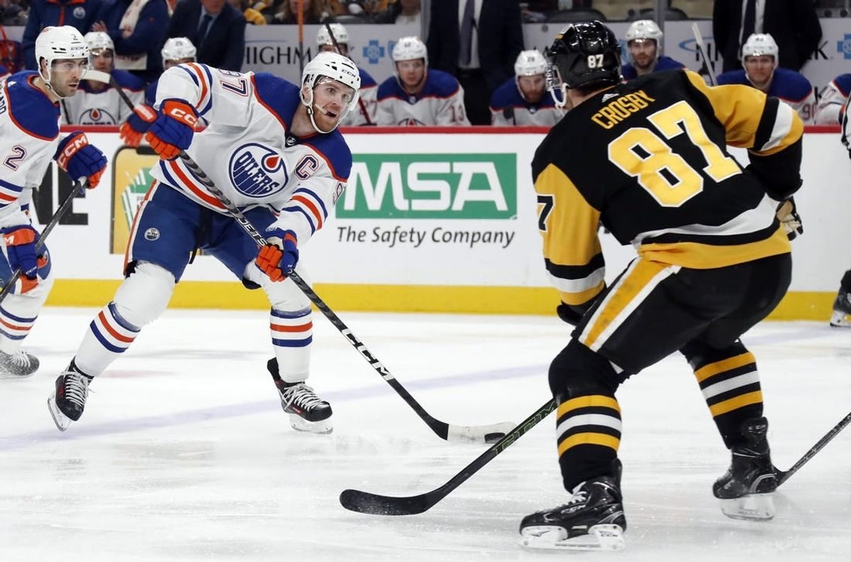 Mar 10, 2024; Pittsburgh, Pennsylvania, USA;  Edmonton Oilers center Connor McDavid (97) skates with the puck as Pittsburgh Penguins Pittsburgh Penguins center Sidney Crosby (87) defends during the second period at PPG Paints Arena.