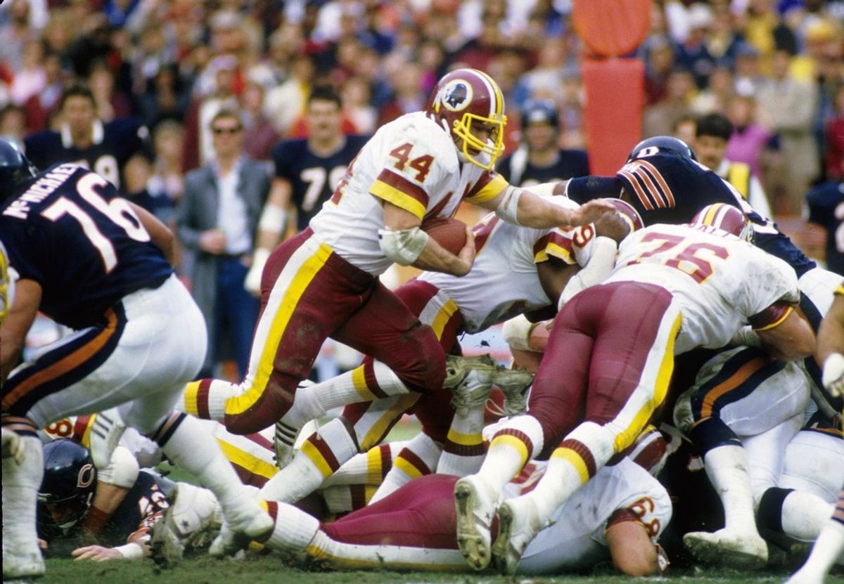 Dec 30, 1984; Washington, DC, USA; FILE PHOTO; Washington Redskins running back John Riggins (44) carries the ball against the Chicago Bears during the 1984 NFC Divisional Playoff Game at RFK Stadium. The Bears won 23-19.  Mandatory Credit: Manny Rubio-Imagn Images