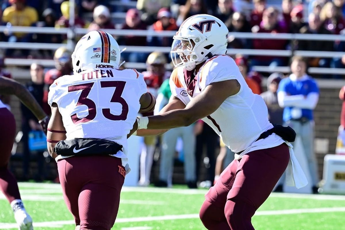 Nov 11, 2023; Chestnut Hill, Massachusetts, USA; Virginia Tech Hokies quarterback Kyron Drones (1) hands the ball to running back Bhayshul Tuten (33) during the first half against the Boston College Eagles at Alumni Stadium.