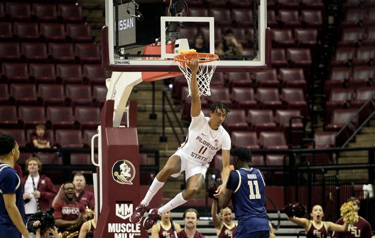 Jan 3, 2024; Tallahassee, Florida, USA; Florida State Seminoles forward Baba Miller (11) hangs on the rim after a dunk during the first half against the Georgia Tech Yellow Jackets at Donald L. Tucker Center.