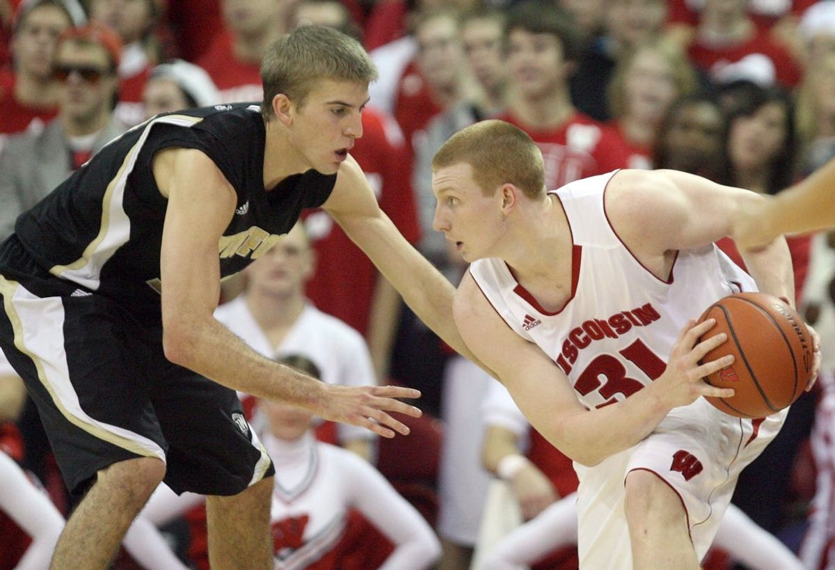 Nov 19, 2011; Madison, WI, USA; Wisconsin Badgers forward Mike Bruesewitz (31) looks to pass the ball past Wofford Terriers guard Kevin Giltner at the Kohl Center. Wisconsin defeated Wofford 69-33. Mandatory Credit: Mary Langenfeld-Imagn Images