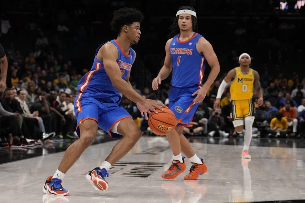 Dec 19, 2023; Charlotte, North Carolina, USA; Florida Gators guard Zyon Pullin (0) handles the ball watched by guard Walter Clayton Jr. (1) during the second half against the Michigan Wolverines at Spectrum Center.