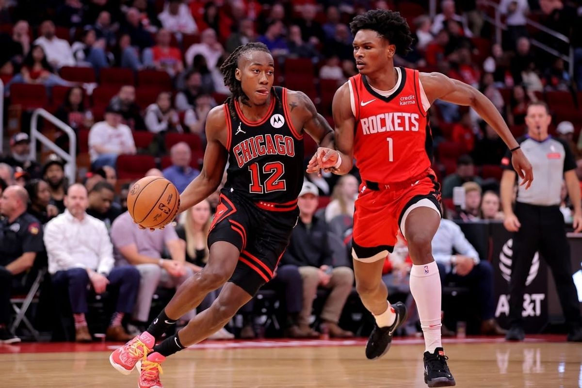 Mar 21, 2024; Houston, Texas, USA; Chicago Bulls guard Ayo Dosunmu (12) handles the ball against Houston Rockets forward Amen Thompson (1) during the second quarter at Toyota Center.