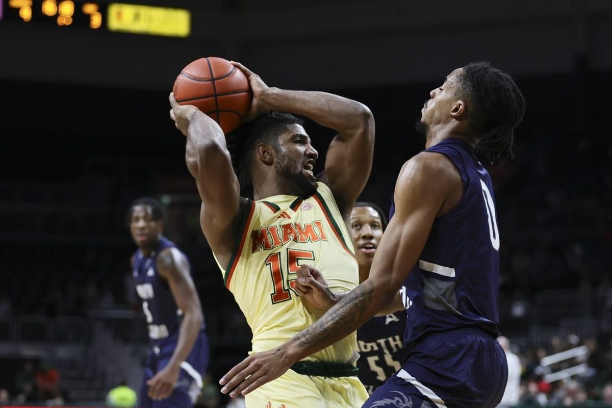 Dec 29, 2023; Coral Gables, Florida, USA; Miami Hurricanes forward Norchad Omier (15) protects the basketball from North Florida Ospreys guard Jasai Miles (0) during the first half at Watsco Center.