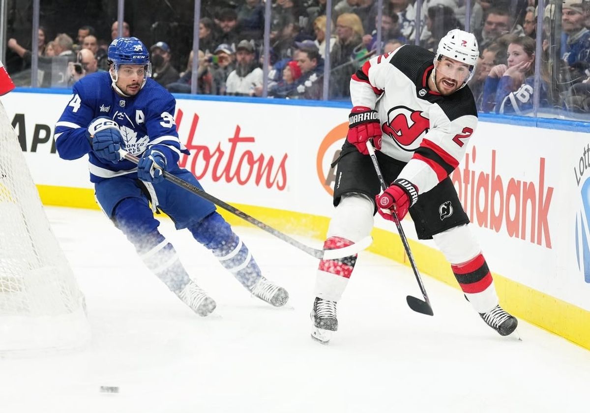 Mar 26, 2024; Toronto, Ontario, CAN; Toronto Maple Leafs center Auston Matthews (34) battles for the puck with New Jersey Devils defenseman Brendan Smith (2) during the first period at Scotiabank Arena.