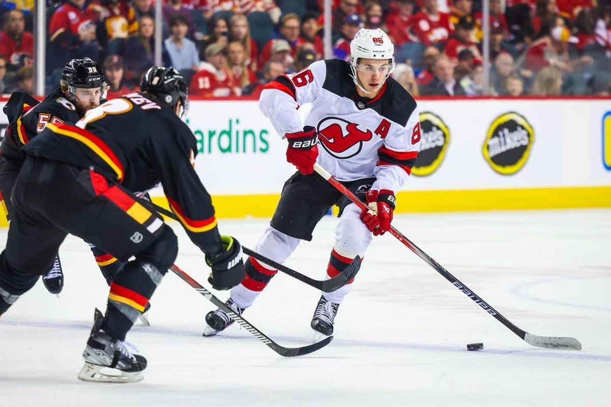 Dec 9, 2023; Calgary, Alberta, CAN; New Jersey Devils center Jack Hughes (86) controls the puck against the Calgary Flames during the first period at Scotiabank Saddledome.