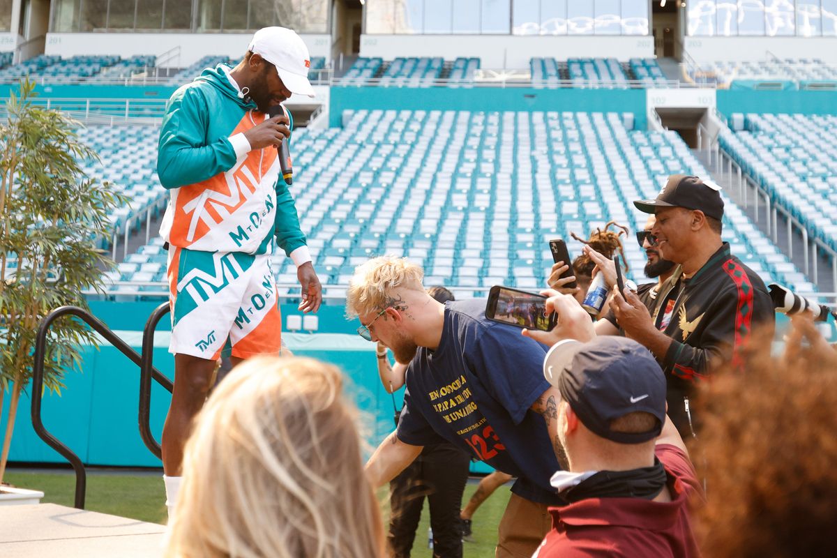 Jake Paul unties Floyd Mayweather’s shoes. How manly.