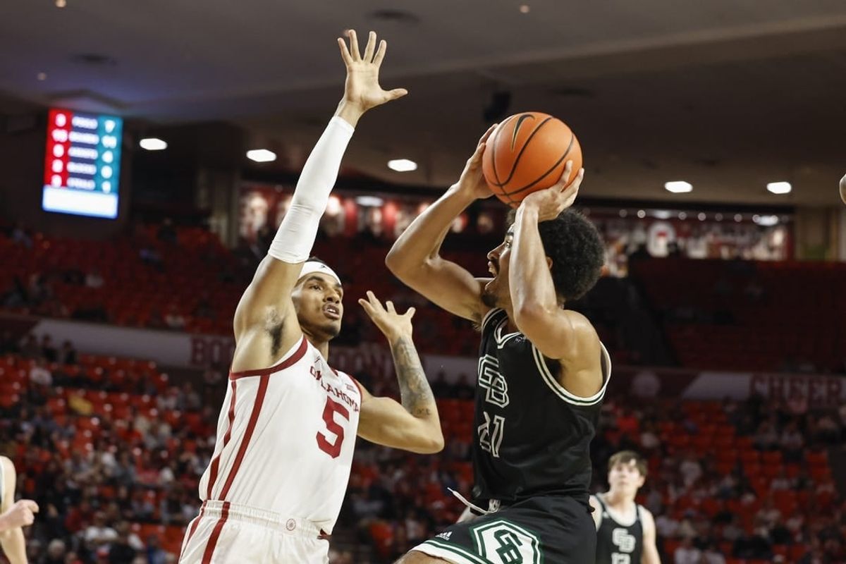 Dec 16, 2023; Norman, Oklahoma, USA; Green Bay Phoenix guard Noah Reynolds (21) shoots against Oklahoma Sooners guard Rivaldo Soares (5) during the first half at Lloyd Noble Center.