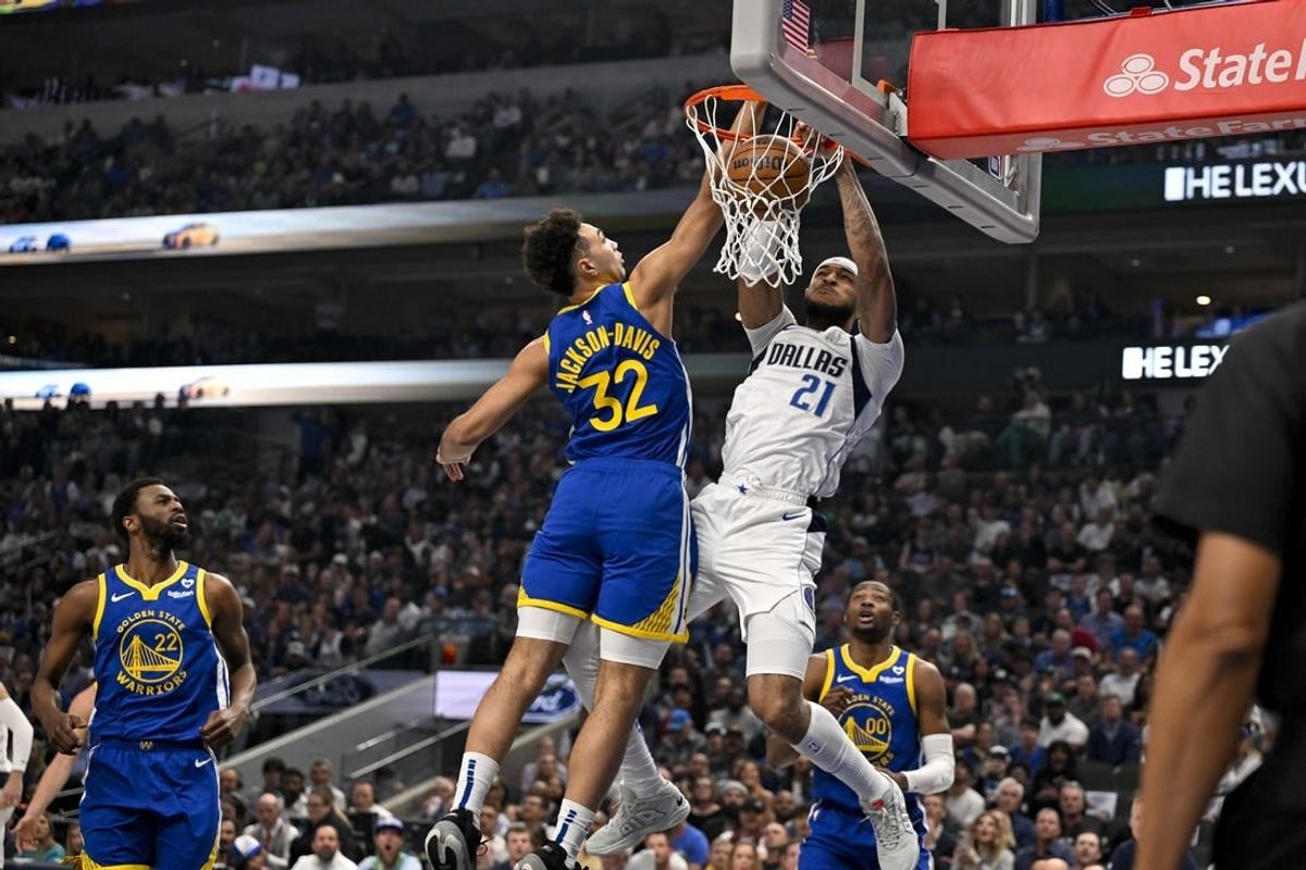 Mar 13, 2024; Dallas, Texas, USA; Dallas Mavericks center Daniel Gafford (21) dunks the ball past Golden State Warriors forward Trayce Jackson-Davis (32) during the first quarter at the American Airlines Center.