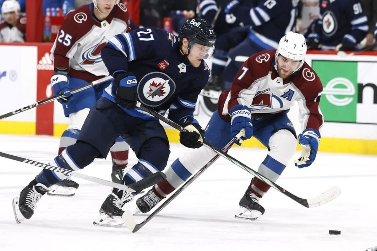 Dec 16, 2023; Winnipeg, Manitoba, CAN; Winnipeg Jets left wing Nikolaj Ehlers (27) is checked by Colorado Avalanche defenseman Devon Toews (7) in the second period at Canada Life Centre.