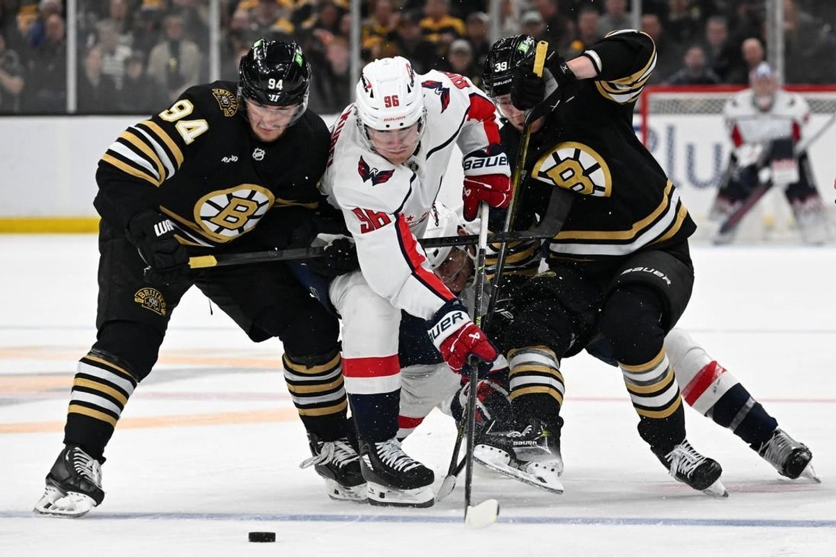 Feb 10, 2024; Boston, Massachusetts, USA; Washington Capitals right wing Nicolas Aube-Kubel (96) battles for the puck against Boston Bruins center Jakub Lauko (94) and center Morgan Geekie (39) during the second period at the TD Garden.