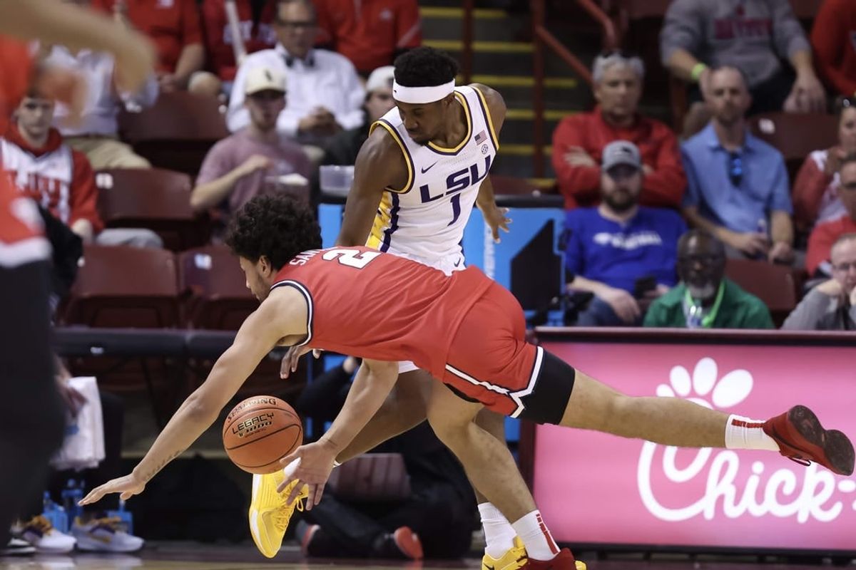 Nov 16, 2023; Charleston, South Carolina, USA;  LSU Tigers guard Carlos Stewart (1) and Dayton Flyers forward Nate Santos (2) scramble for a ball in the first half at TD Arena.
