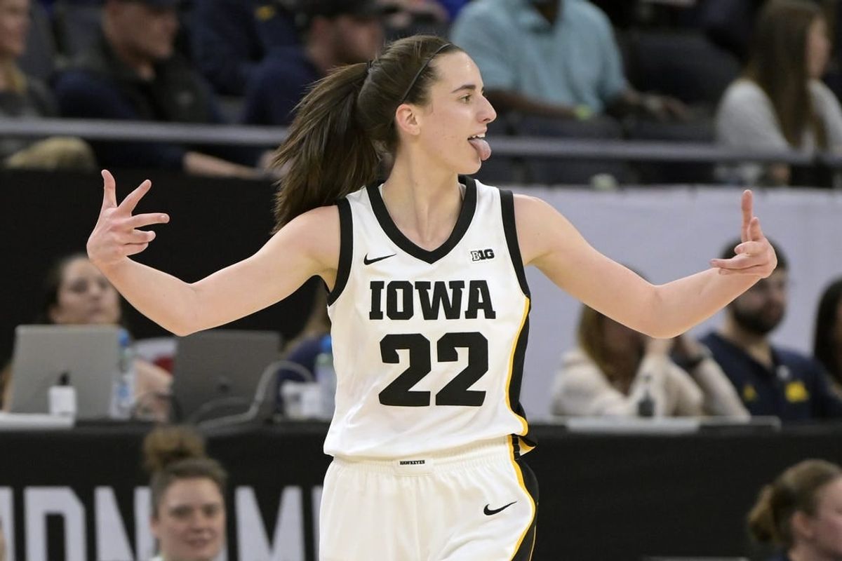 Mar 9, 2024; Minneapolis, MN, USA;  Iowa Hawkeyes guard Caitlin Clark (22) celebrates a three-pointer just inside the half-court line Michigan Wolverines during the first half of the Big Ten Women's Basketball tournament semifinal at Target Center.