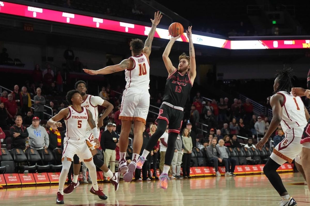 Nov 29, 2023; Los Angeles, California, USA; Eastern Washington Eagles guard Jake Kyman (13) shoots the ball against Southern California Trojans forward DJ Rodman (10)  in the first half at Galen Center.