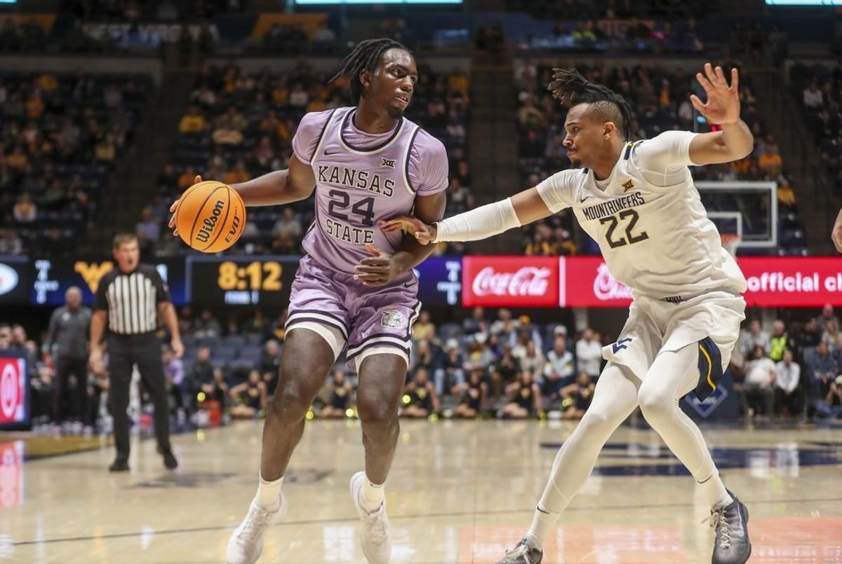 Jan 9, 2024; Morgantown, West Virginia, USA; Kansas State Wildcats forward Arthur Kaluma (24) dribbles against West Virginia Mountaineers forward Josiah Harris (22) during the first half at WVU Coliseum.