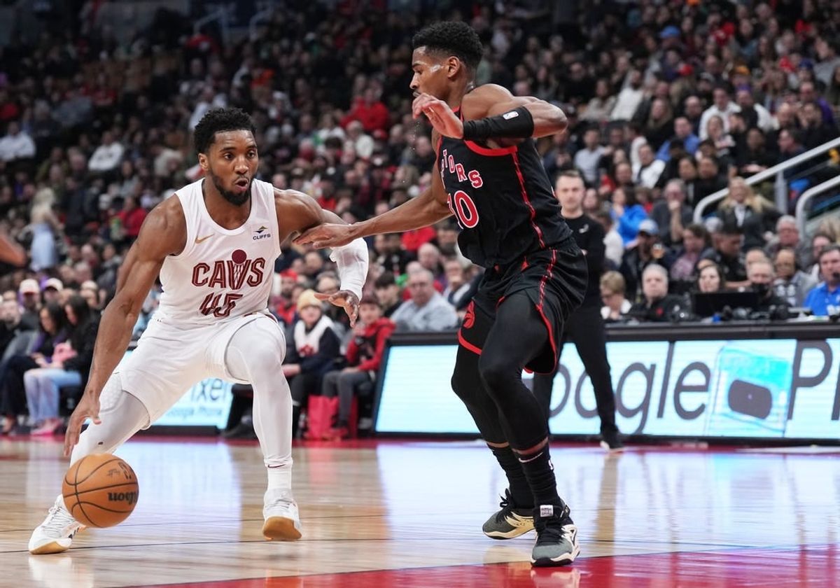 Feb 10, 2024; Toronto, Ontario, CAN; Cleveland Cavaliers guard Donovan Mitchell (45) controls the ball as Toronto Raptors guard Ochai Agbaji (30) tries to defend during the second quarter at Scotiabank Arena .