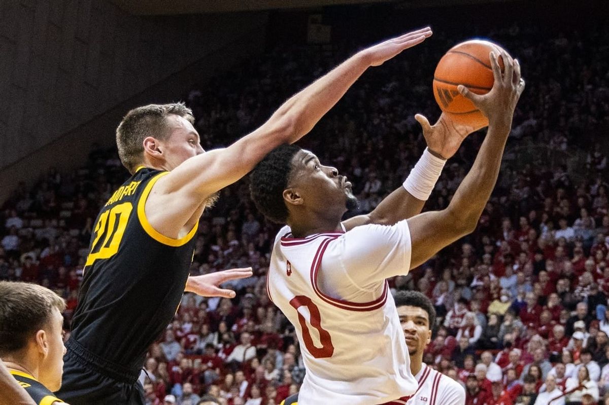 Jan 30, 2024; Bloomington, Indiana, USA; Indiana Hoosiers guard Xavier Johnson (0) shoots the ball while Iowa Hawkeyes forward Payton Sandfort (20) defends in the first half at Simon Skjodt Assembly Hall.