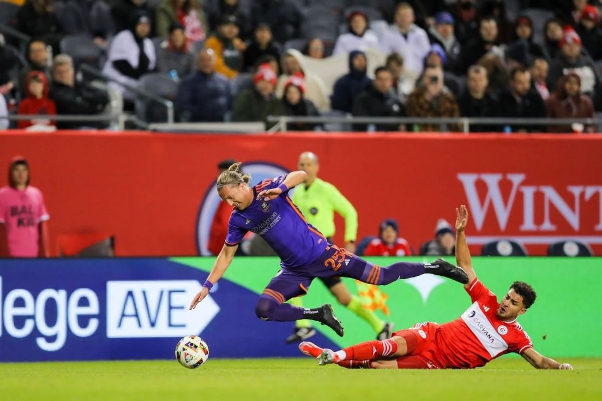Apr 6, 2024; Chicago, Illinois, USA; Chicago Fire FC defender Allan Arigoni (27) slide tackles Houston Dynamo FC midfielder Griffin Dorsey (25) during the first half at Soldier Field.