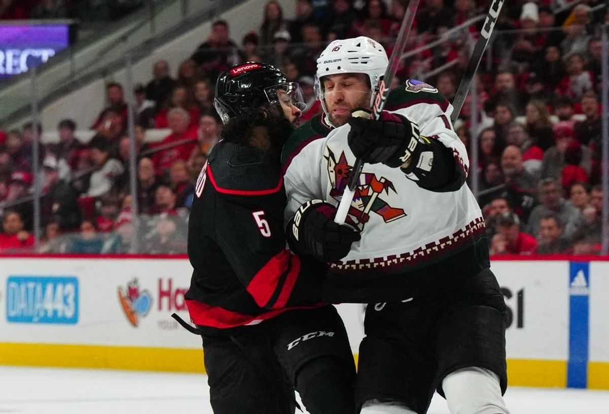 Jan 27, 2024; Raleigh, North Carolina, USA; Arizona Coyotes left wing Jason Zucker (16) checks Carolina Hurricanes defenseman Jalen Chatfield (5) during the first period at PNC Arena.