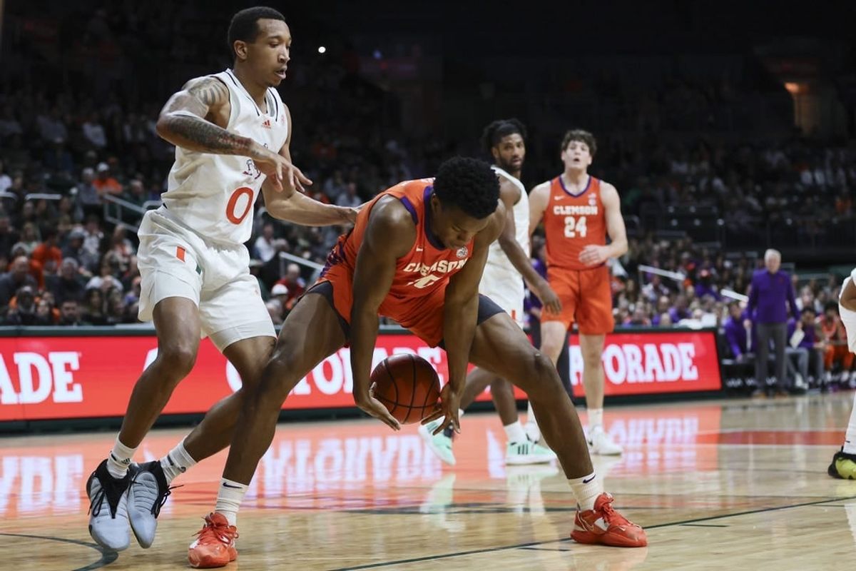 Jan 3, 2024; Coral Gables, Florida, USA; Clemson Tigers forward RJ Godfrey (10) protects the basketball from Miami Hurricanes guard Matthew Cleveland (0) during the first half at Watsco Center.