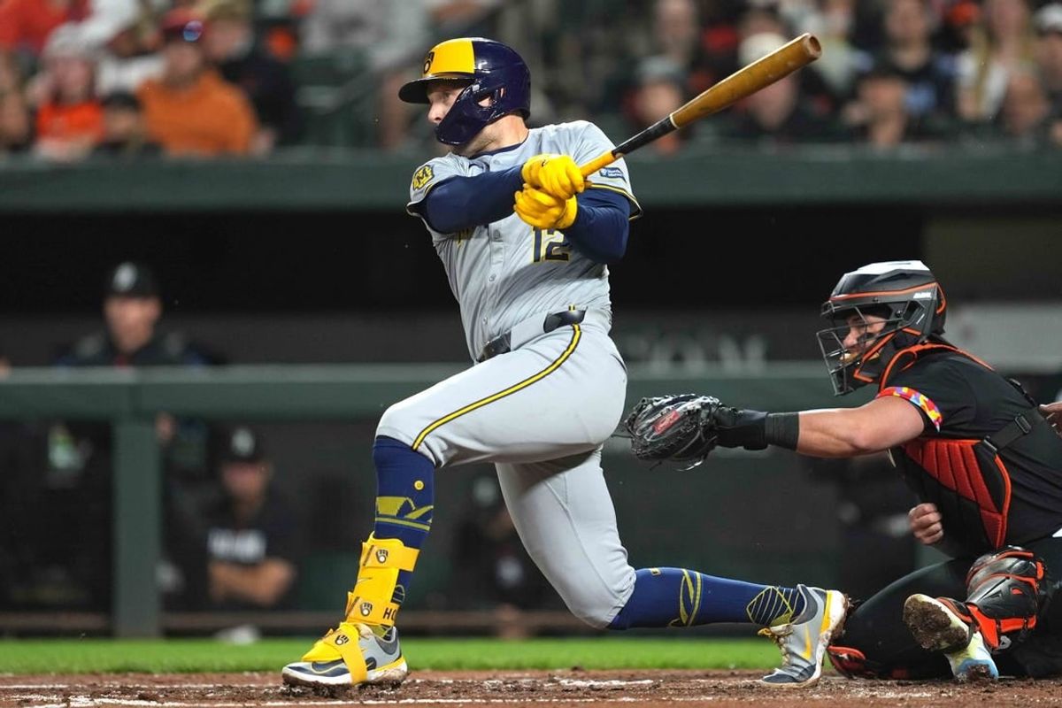 Apr 12, 2024; Baltimore, Maryland, USA; Milwaukee Brewers first baseman Rhys Hoskins (12) singles in the third inning to drive in shortstop Willy Adames (not shown) against the Baltimore Orioles at Oriole Park at Camden Yards.