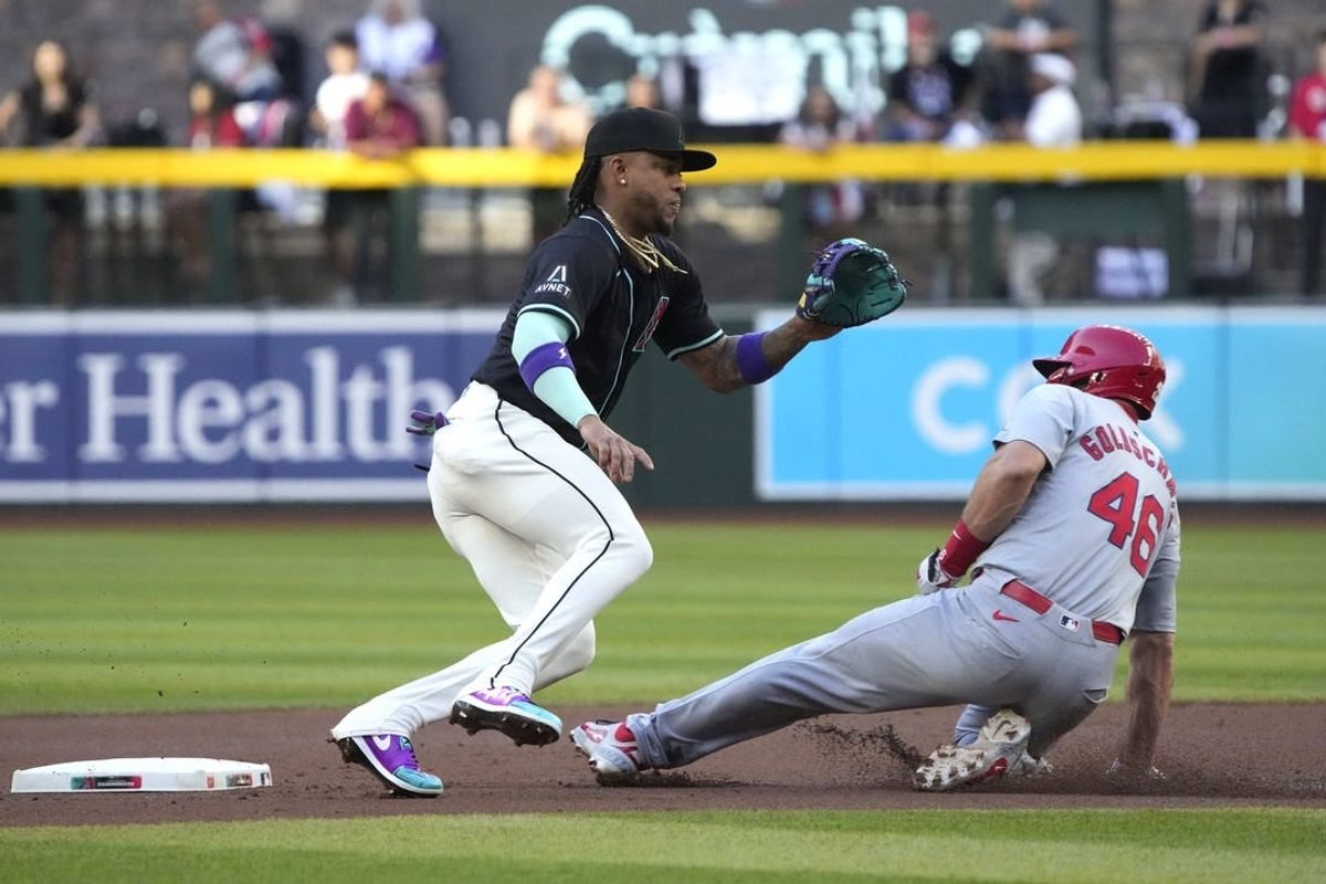 Apr 13, 2024; Phoenix, Arizona, USA; St. Louis Cardinals first baseman Paul Goldschmidt (46) advances to secondbase under the tag of Arizona Diamondbacks second baseman Ketel Marte (4) on a wild pitch in the first inning at Chase Field.