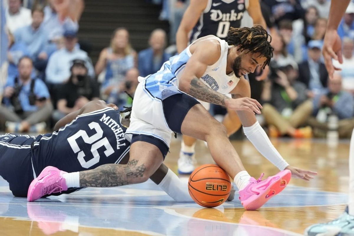 Feb 3, 2024; Chapel Hill, North Carolina, USA;  Duke Blue Devils forward Mark Mitchell (25) and North Carolina Tar Heels guard RJ Davis (4) fight for the ball in the first half at Dean E. Smith Center.