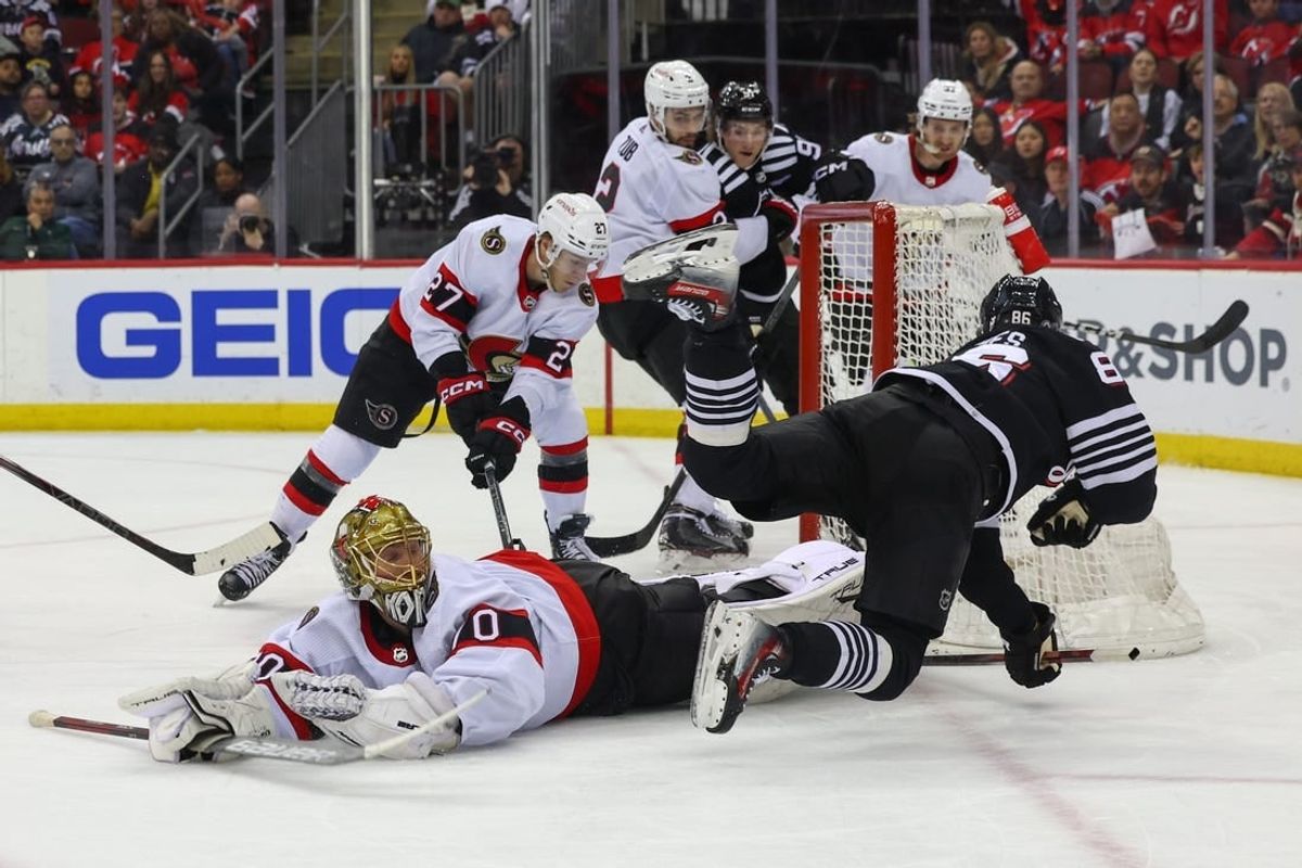 Mar 23, 2024; Newark, New Jersey, USA; Ottawa Senators goaltender Joonas Korpisalo (70) makes a save on New Jersey Devils center Jack Hughes (86) during the second period at Prudential Center.