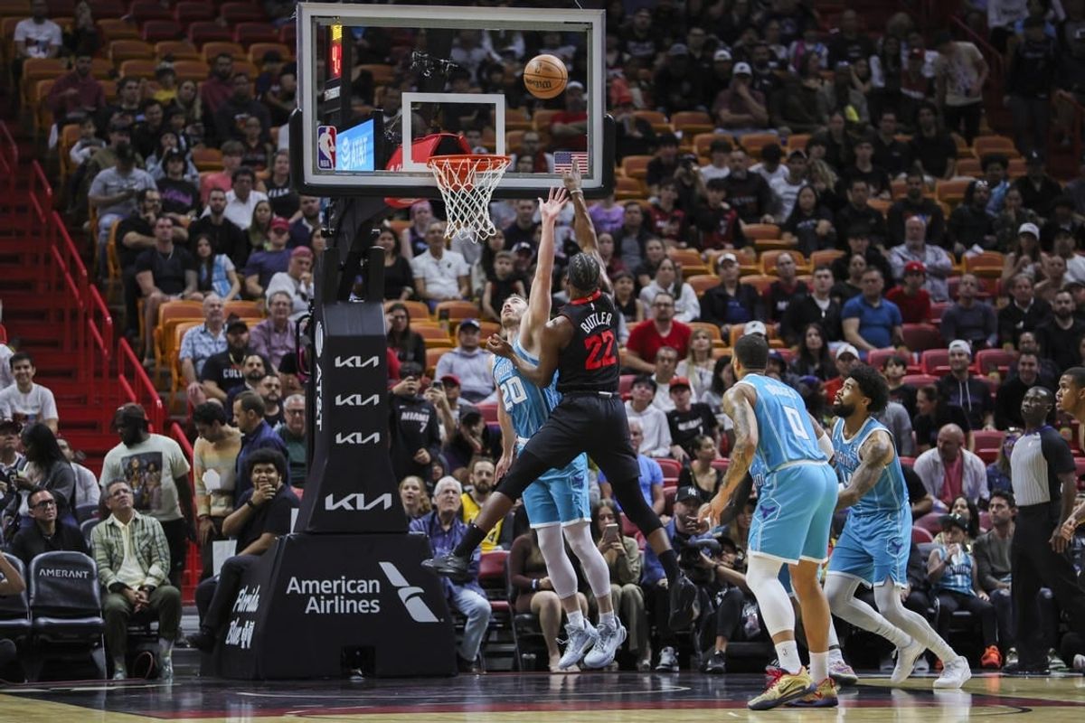 Dec 13, 2023; Miami, Florida, USA; Miami Heat forward Jimmy Butler (22) shoots the basketball over Charlotte Hornets forward Gordon Hayward (20) during the first quarter at Kaseya Center.
