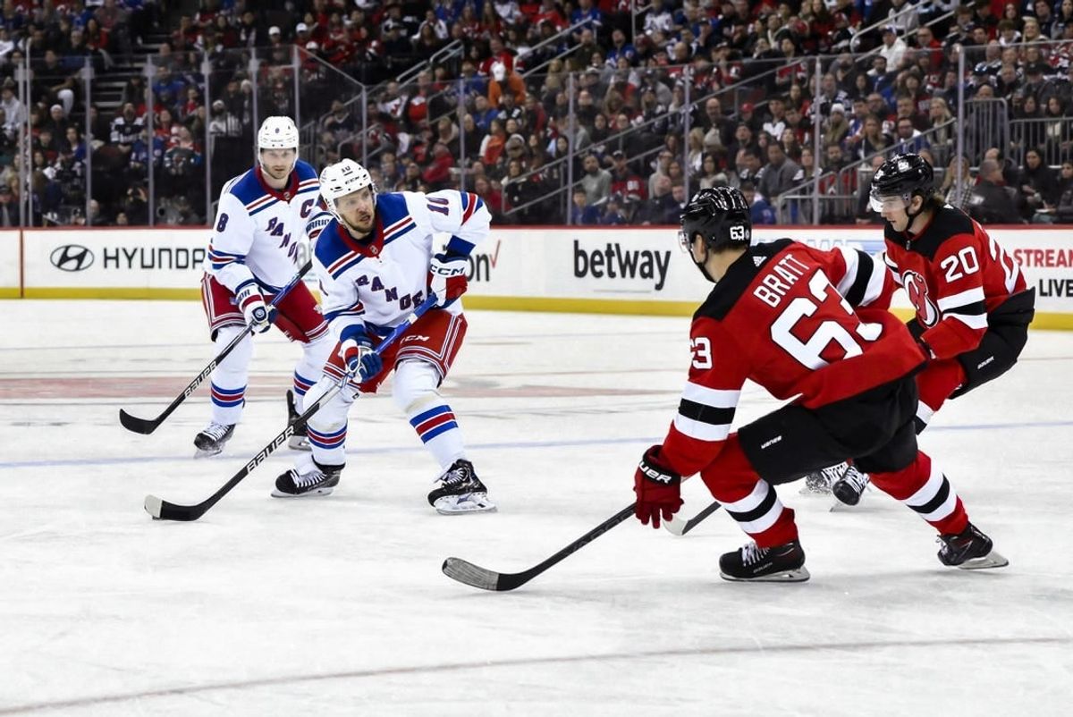 Nov 18, 2023; Newark, New Jersey, USA; New York Rangers left wing Artemi Panarin (10) skates with the puck against New Jersey Devils left wing Jesper Bratt (63) and New Jersey Devils center Michael McLeod (20) during the first period at Prudential Center.
