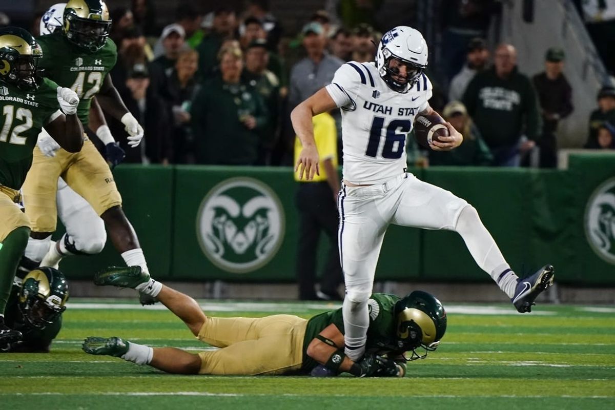 Oct 15, 2022; Fort Collins, Colorado, USA; Utah State Aggies quarterback Levi Williams (16) can't escape the grasp of a Colorado State Rams defender at Sonny Lubick Field at Canvas Stadium.
