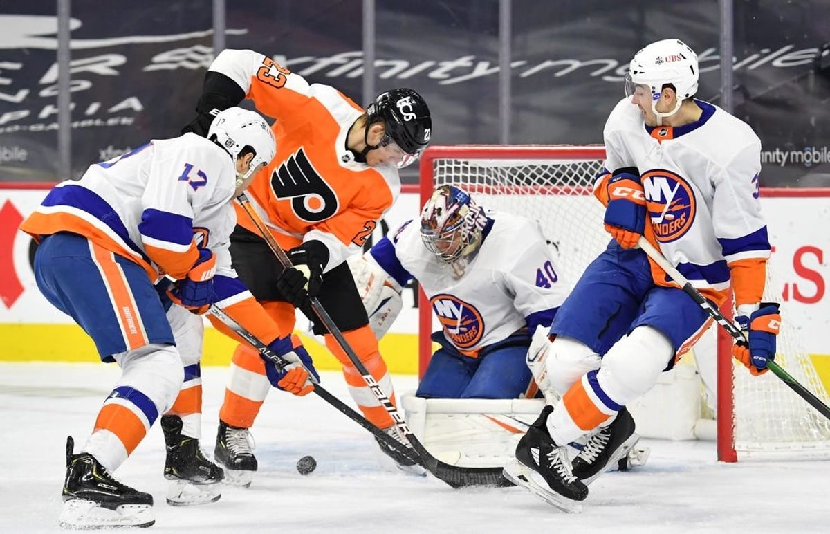 Jan 30, 2021; Philadelphia, Pennsylvania, USA; Philadelphia Flyers left wing Oskar Lindblom (23) battles for the puck with New York Islanders left wing Matt Martin (17) and defenseman Adam Pelech (3) in front of goaltender Semyon Varlamov (40) during the second period at Wells Fargo Center.