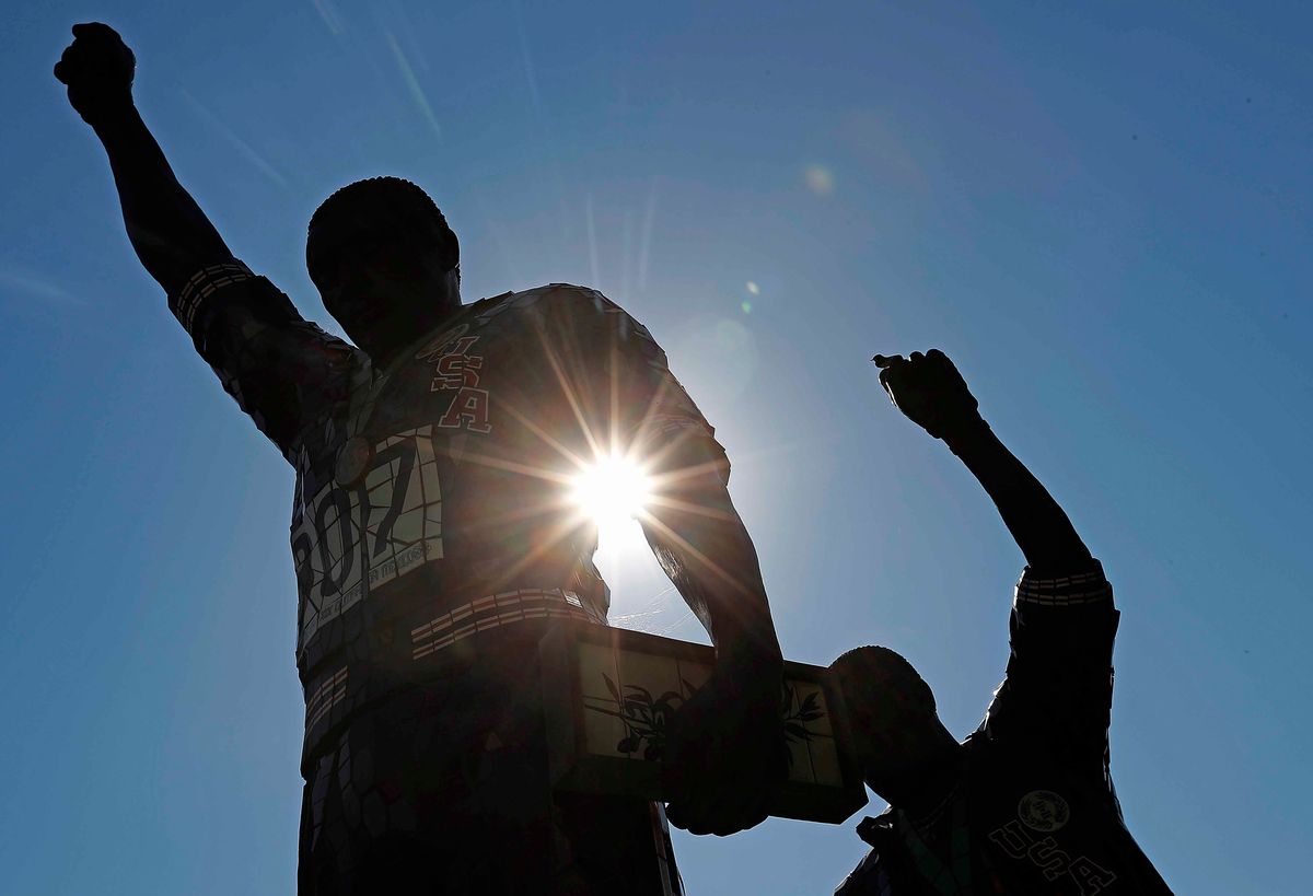 Sunlight peeks through statue on San Jose State University campus that honors Olympians Tommie Smith’s and John C arlos’ protest at 1968 Games.