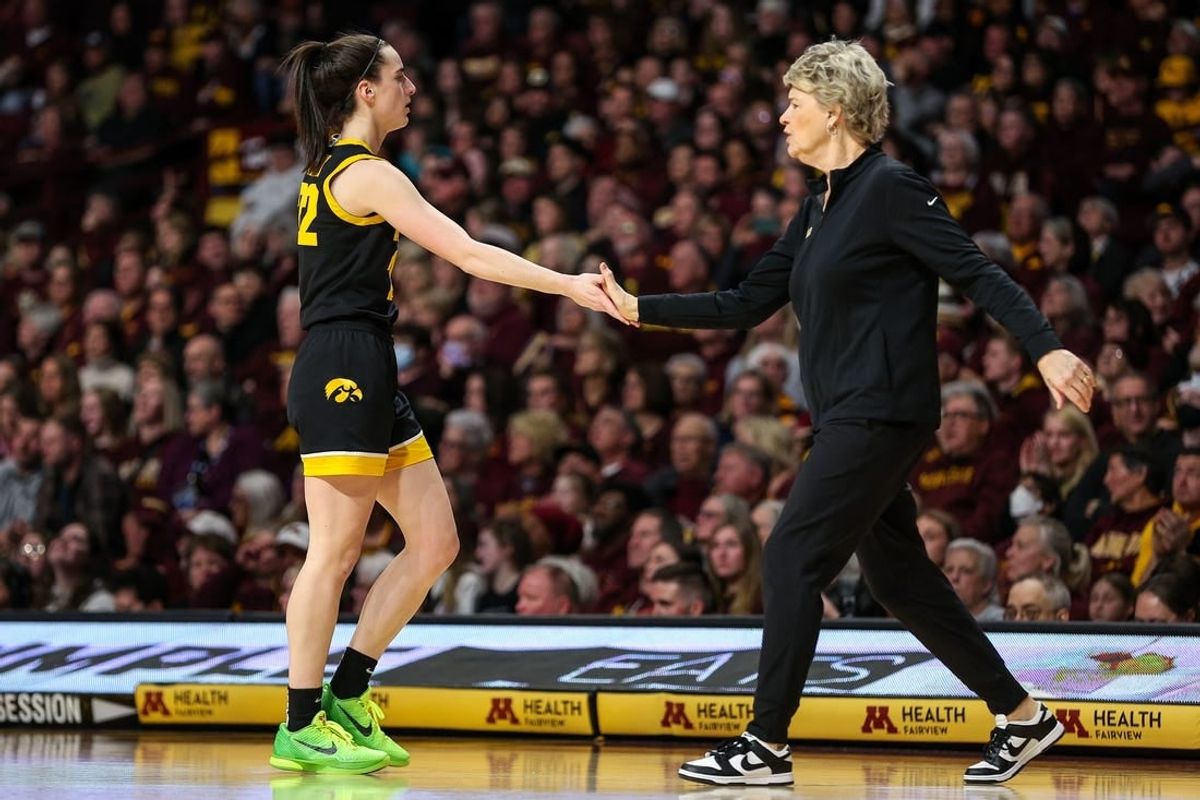 Iowa Hawkeyes guard Caitlin Clark (22) and head coach Lisa Bluder react during the first half against the Minnesota Golden Gophers at Williams Arena.