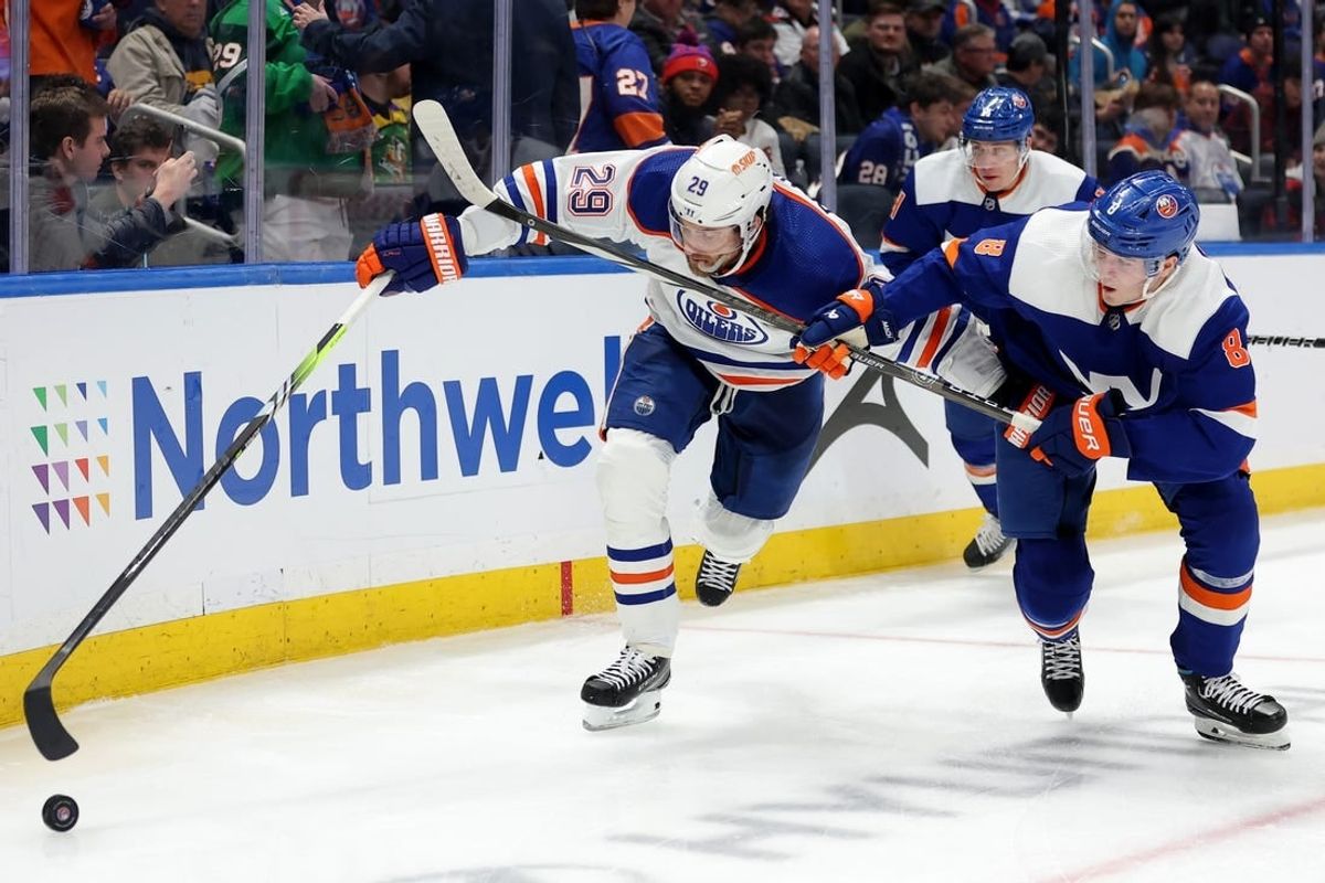 Dec 19, 2023; Elmont, New York, USA; Edmonton Oilers center Leon Draisaitl (29) fights for the puck against New York Islanders defenseman Noah Dobson (8) during the third period at UBS Arena.